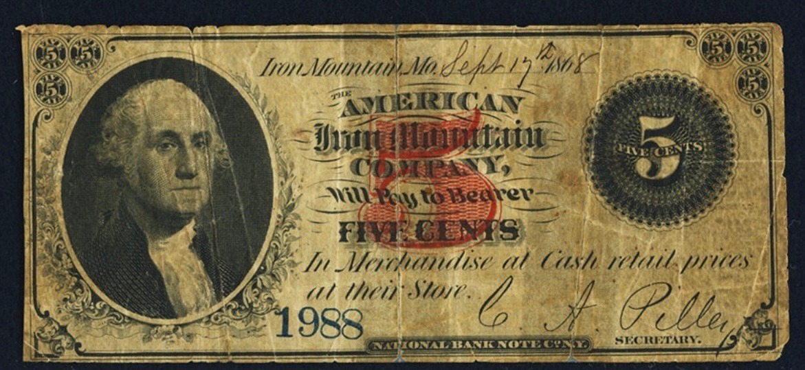 A five-cent scrip note of the American Iron Mountain Company, dated Iron Mountain, Mo., September 17th, 1868: George Washington in an oval at left, a large red 5 protector at center, serial number 1988 in blue, signed by the company secretary, promising to pay the bearer five cents in merchandise at cash retail prices at their store. Printed by the National Bank Note Co., New York.